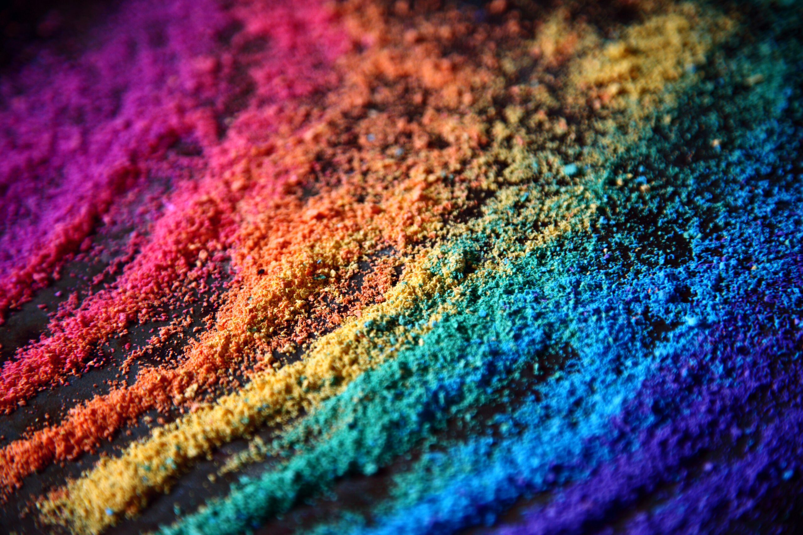 rainbow colored dust from crayons with finger marks running through